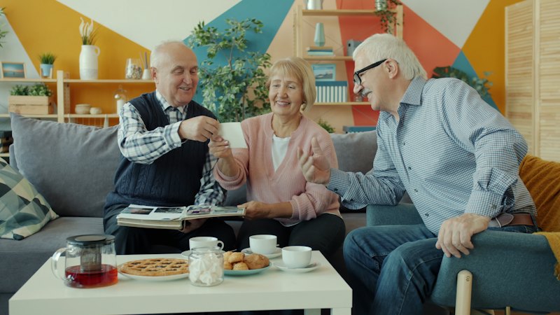 Older family members sharing photographs over tea